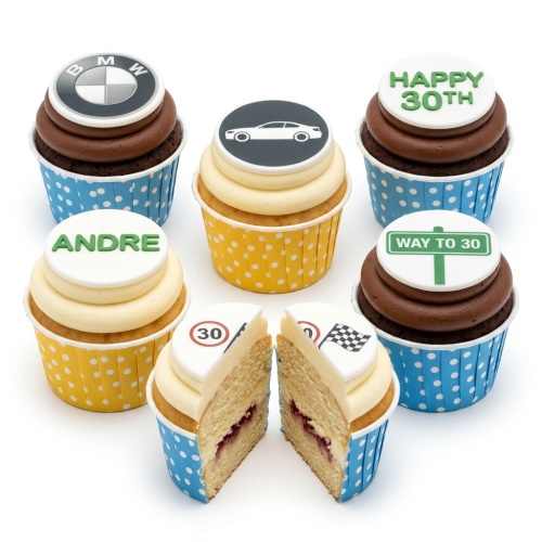 Assortment of driving theme birthday cupcakes with car, BMW logo, racing flag, and custom age toppers.
