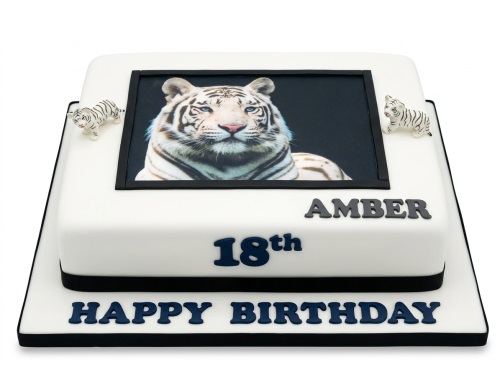 White tiger birthday cake with custom name and age, featuring an edible image and tiger figurines.