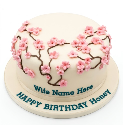 Round cream cake with pink cherry blossom flowers and custom message