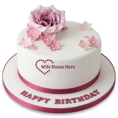White round cake with pink sugar flowers, a large rose, and a custom message.