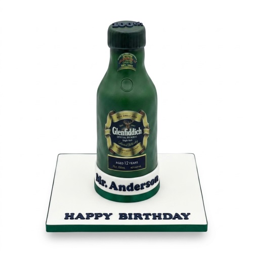 3D sculpted green whisky bottle birthday cake with gold label on a white board with 'Happy Birthday' message.