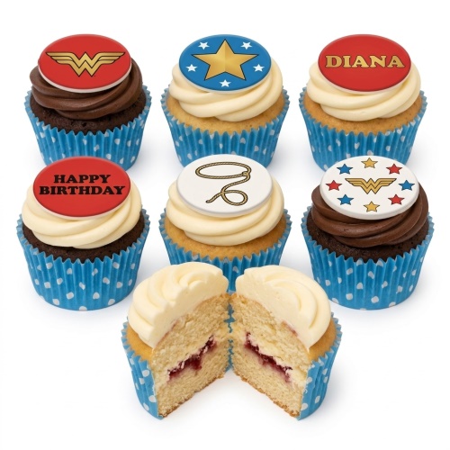 Set of Wonder Woman themed cupcakes with red, blue, and gold toppers, some with logo, star, lasso, and 'Happy Birthday' message. One cupcake is cut open revealing jam filling.