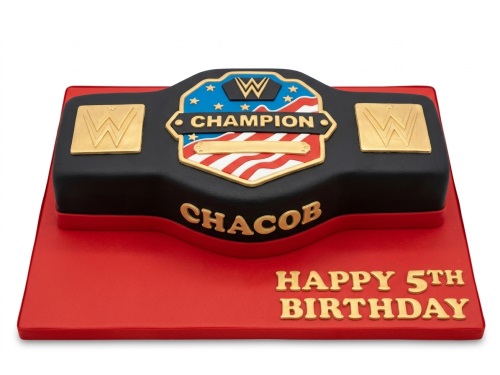 Rectangular black cake shaped like a WWE Championship Belt with gold, red, white, and blue details on a red cake board.
