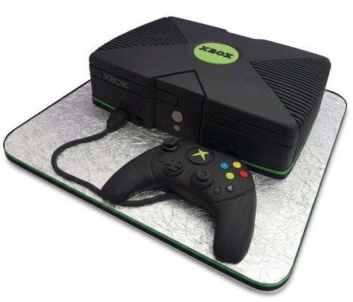 Black Xbox console cake with green logo and matching controller on a silver board.