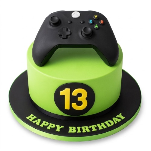 Green round birthday cake with black Xbox controller on top, custom age number 13, and 'Happy Birthday' message.