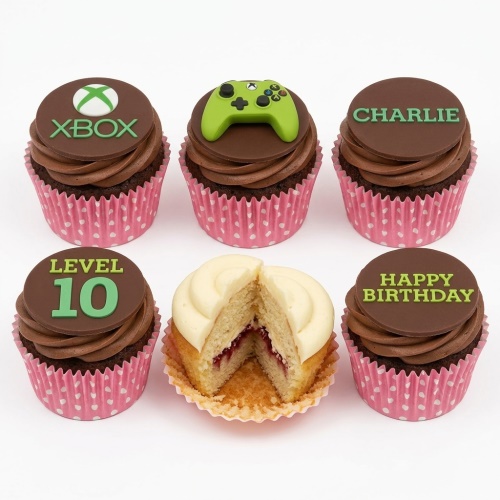 Chocolate cupcakes with Xbox logo, green controller, and custom age/message toppers in pink cases.