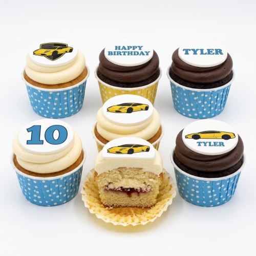 A selection of vanilla and chocolate cupcakes with yellow sports car toppers, a custom age topper, and a 'Happy Birthday' message.