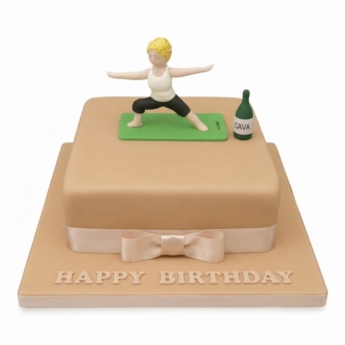 Two-tiered square cake with a woman in a yoga pose on a mat, a Cava bottle, and a 'Happy Birthday' message.