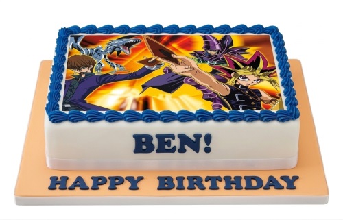 Rectangular white Yu-Gi-Oh! themed birthday cake with blue piping and edible character image.