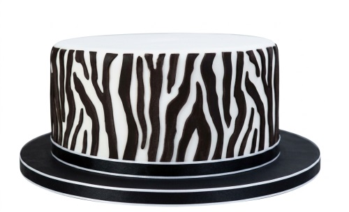 Round single-tier cake with black and white zebra print design and black ribbon trim.
