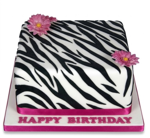 Square zebra print birthday cake with black and white stripes, pink flowers, and a "Happy Birthday" message.
