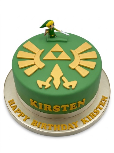 Round green fondant cake with gold Triforce and Hylian Crest, topped with a Link figurine, with custom name on the side and birthday message on the board.